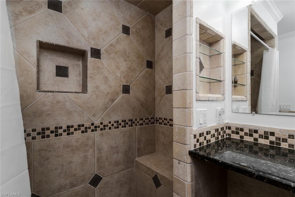 Full bathroom with tiled shower and tasteful backsplash