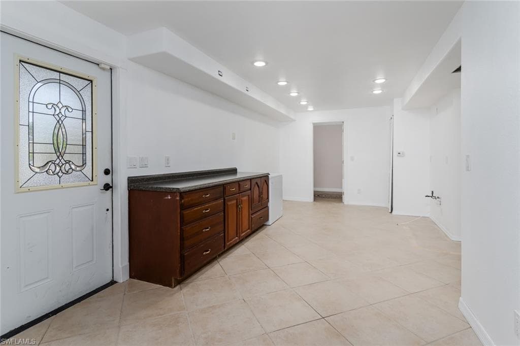 efficient area of Kitchen with dark countertops, recessed lighting, and light tile patterned floors