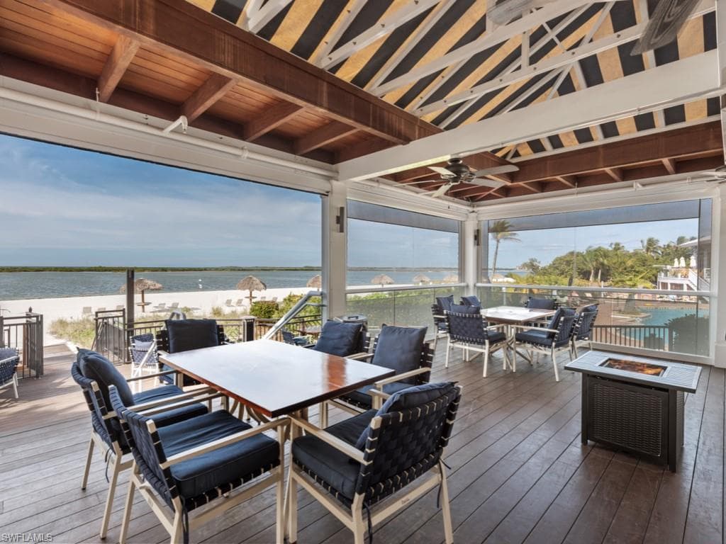 Deck featuring outdoor dining area, a water view, and a ceiling fan