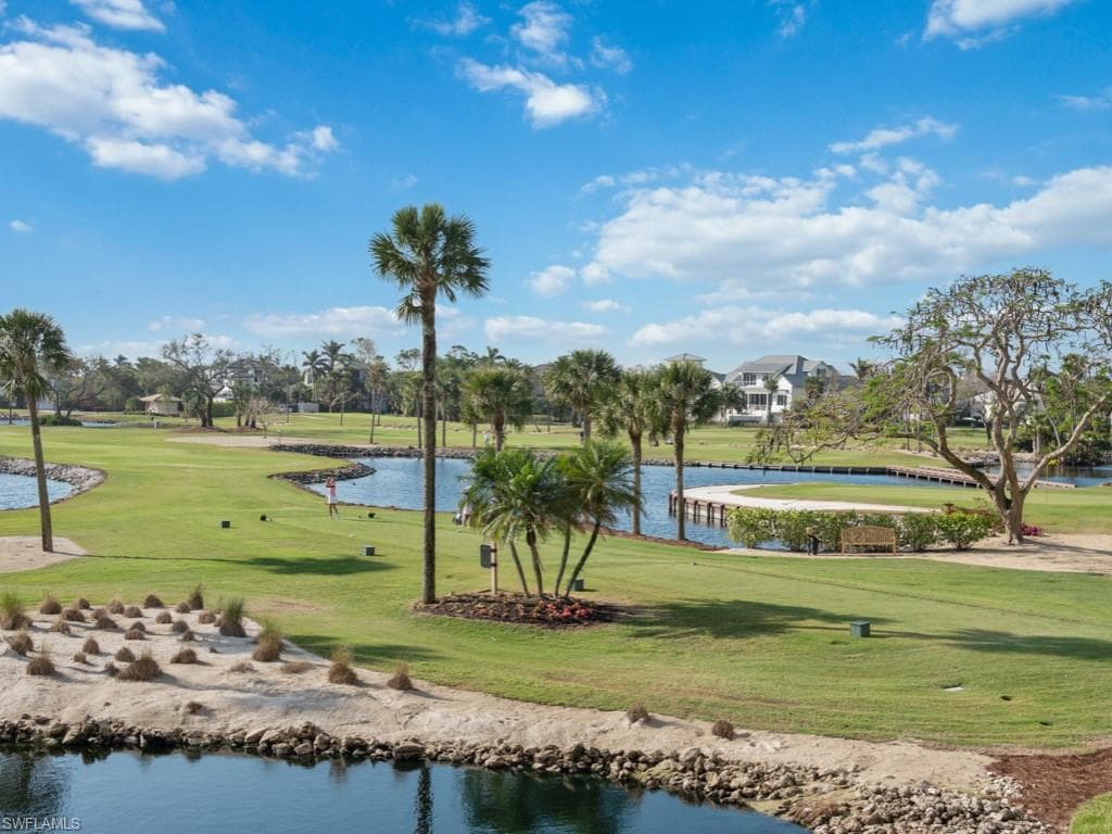 View of property's community featuring a water view, a yard, and golf course view
