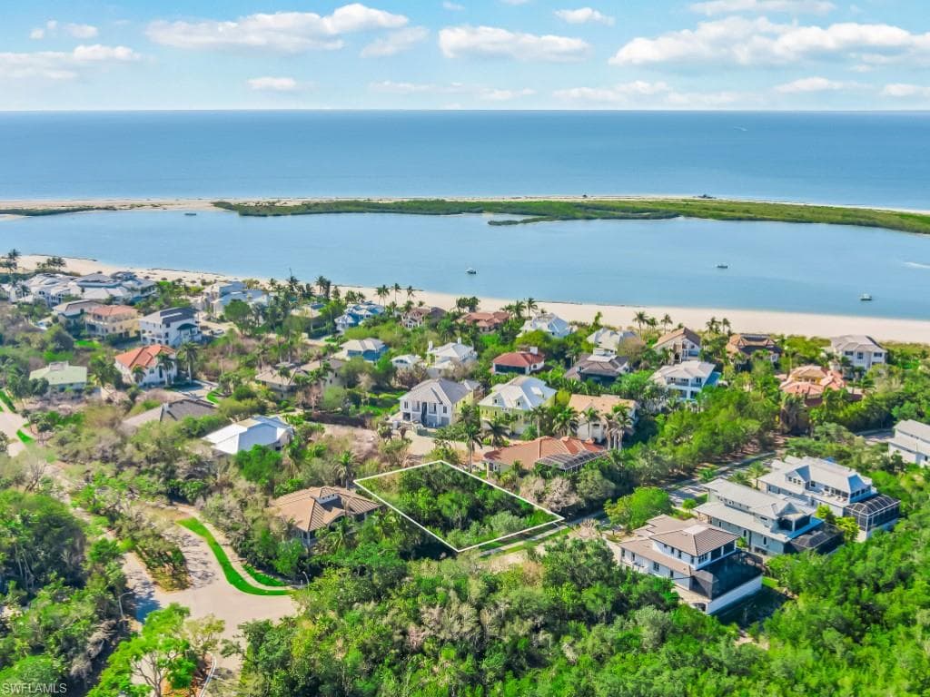 Aerial view of residential area featuring a nearby body of water and property boundaries highlighted