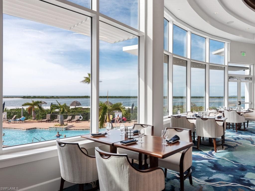 Dining area with a water view, carpet floors, and a high ceiling