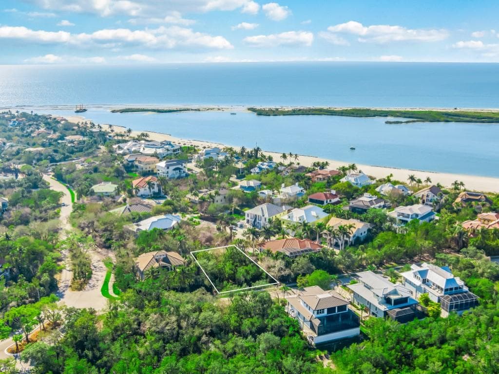 Aerial perspective of suburban area with property boundaries highlighted and a large body of water