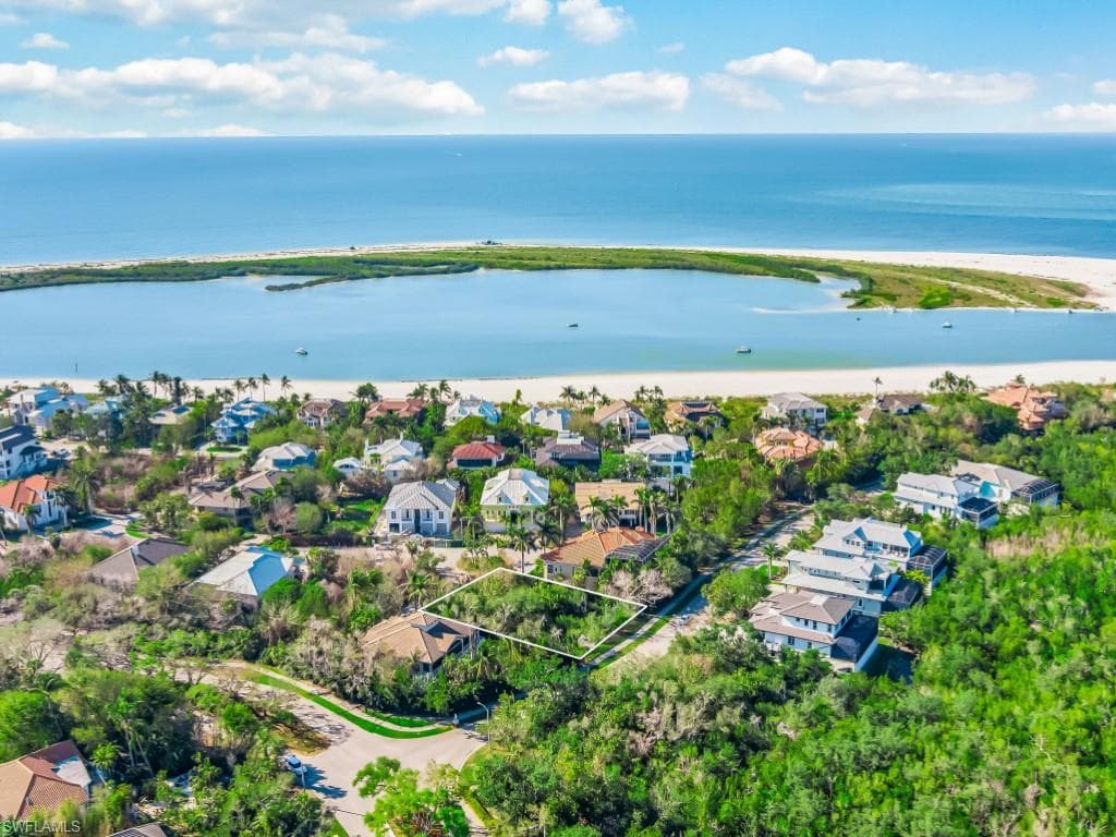 Aerial view of residential area with a nearby body of water and property boundaries highlighted
