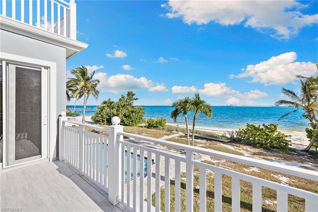 Balcony with view of water and beach