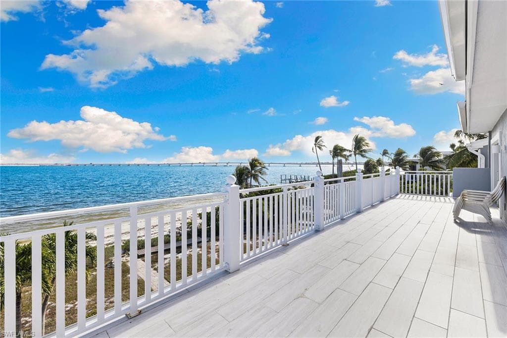 Wooden terrace featuring a water view and a patio area
