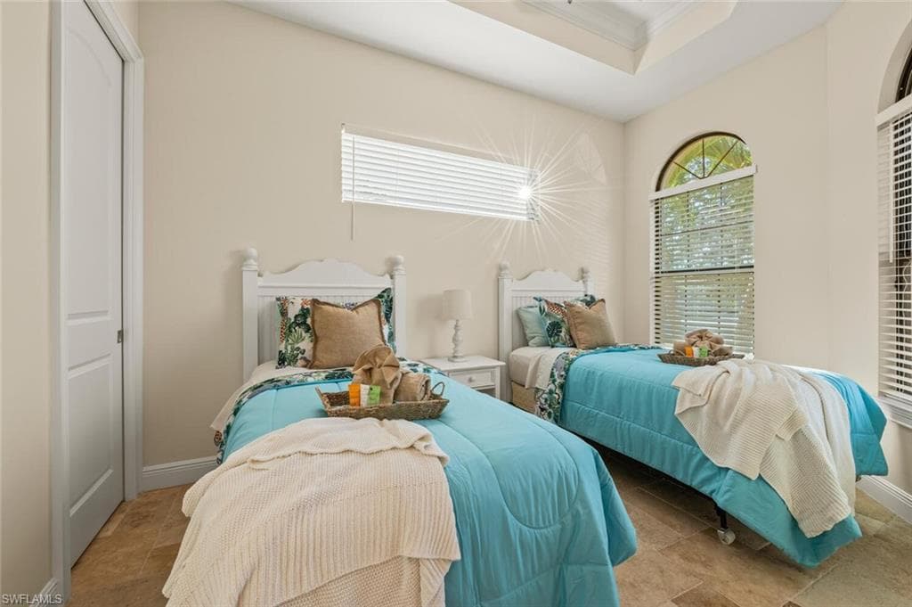 Bedroom with a tray ceiling and crown molding