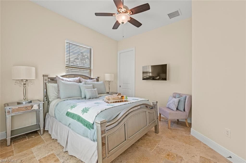 Bedroom featuring stone tile floors and a ceiling fan