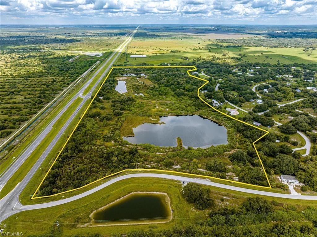 Aerial view of property and surrounding area with a large body of water and property parcel outlined