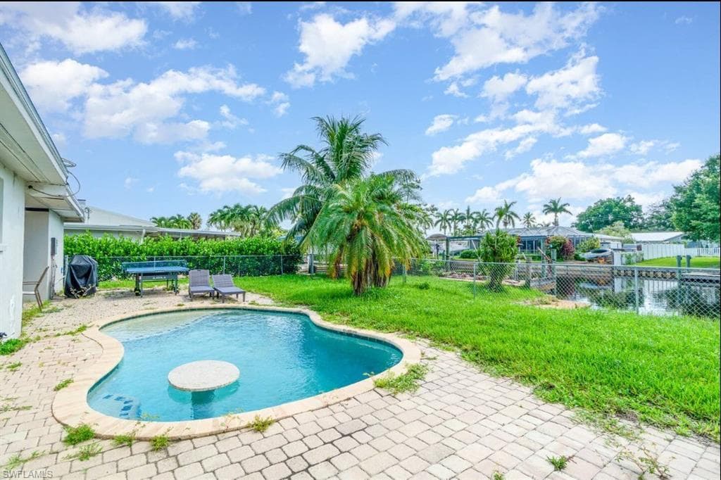 View of pool featuring a patio, a fenced backyard, and grilling area