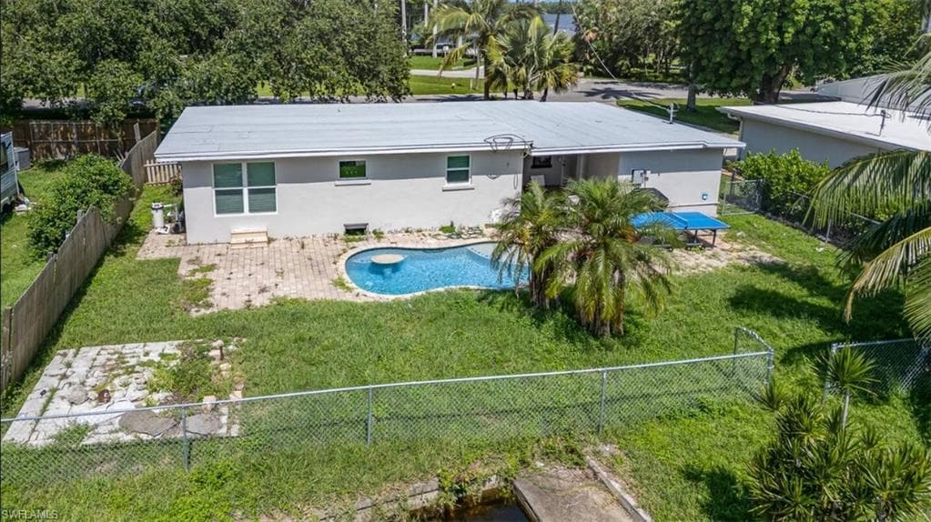 Rear view of property with stucco siding and a fenced backyard
