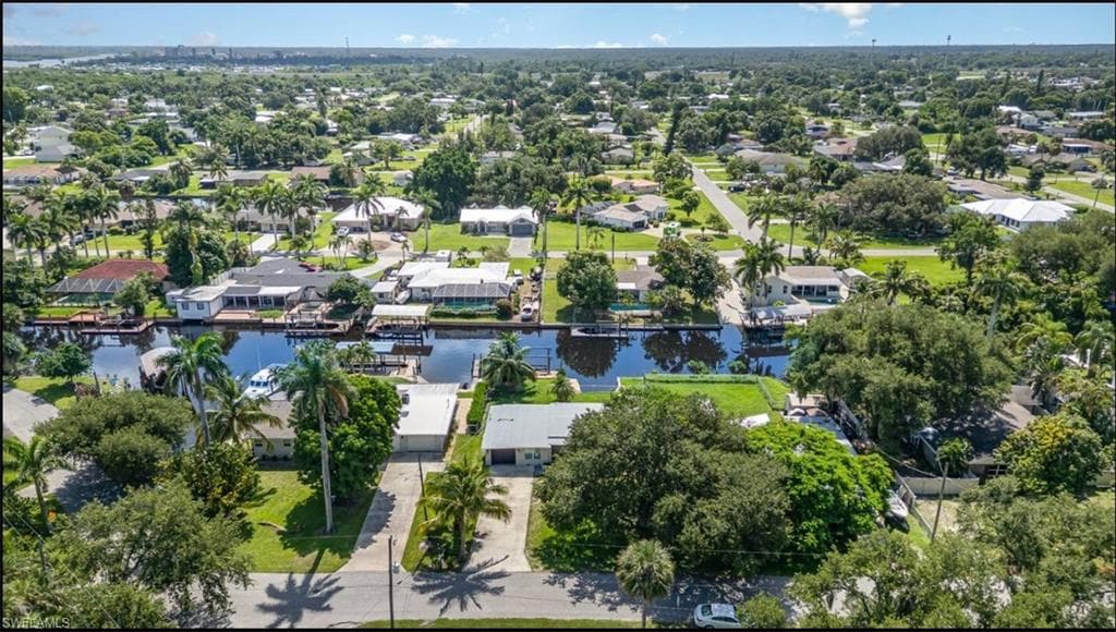 Aerial view of property and surrounding area with a large body of water and nearby suburban area