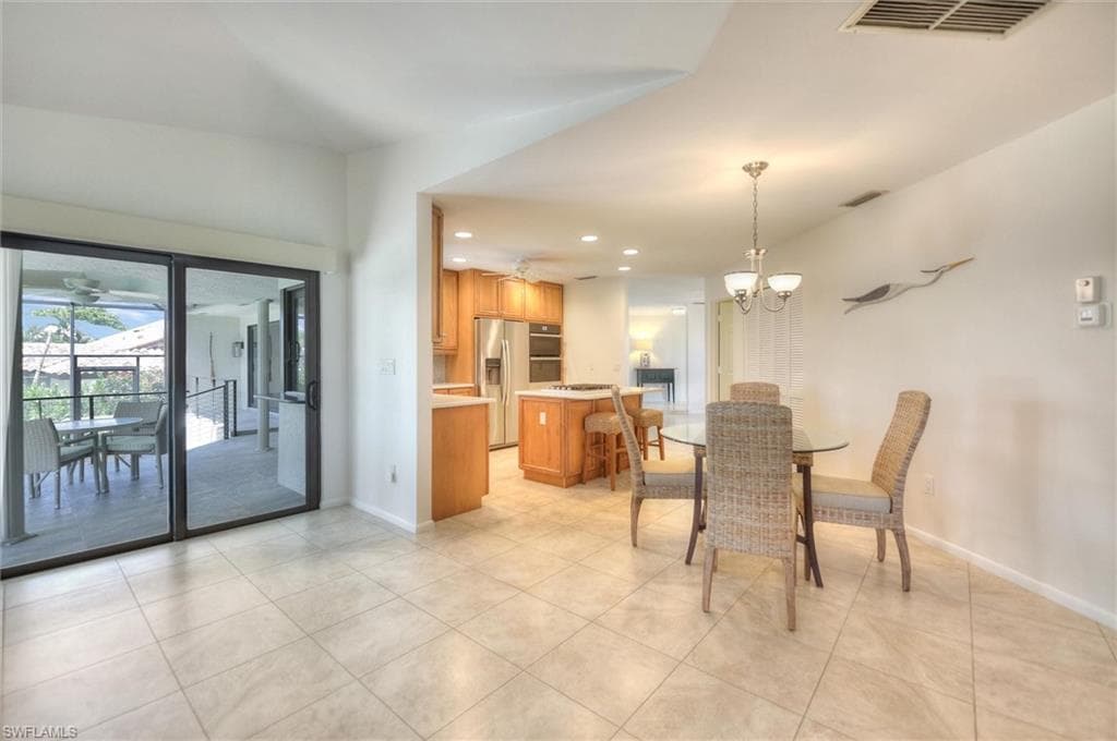 Living area with light tile patterned floors and a chandelier