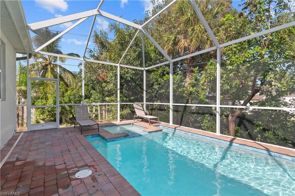 View of swimming pool featuring a patio, a lanai, and a pool with connected hot tub