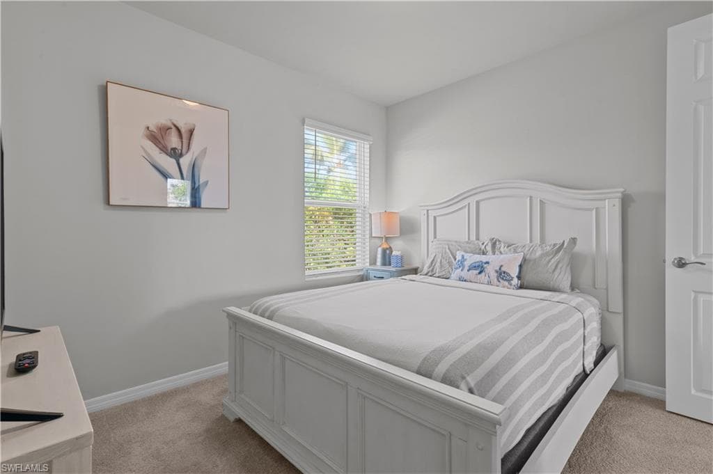 Bedroom with light carpet and baseboards