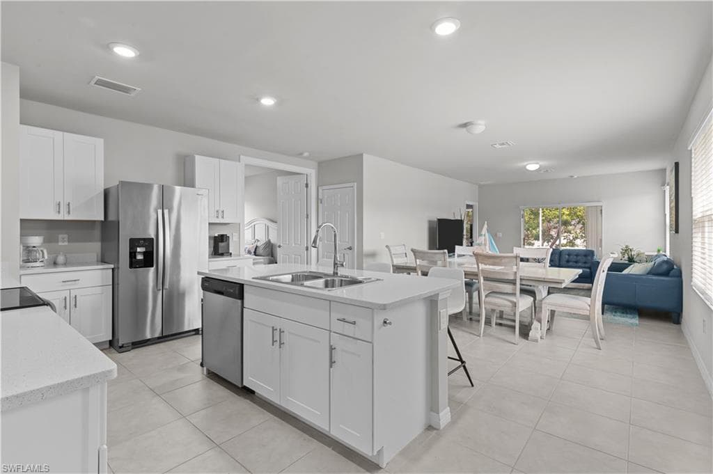 Kitchen featuring appliances with stainless steel finishes, light tile patterned floors, white cabinetry, and recessed lighting
