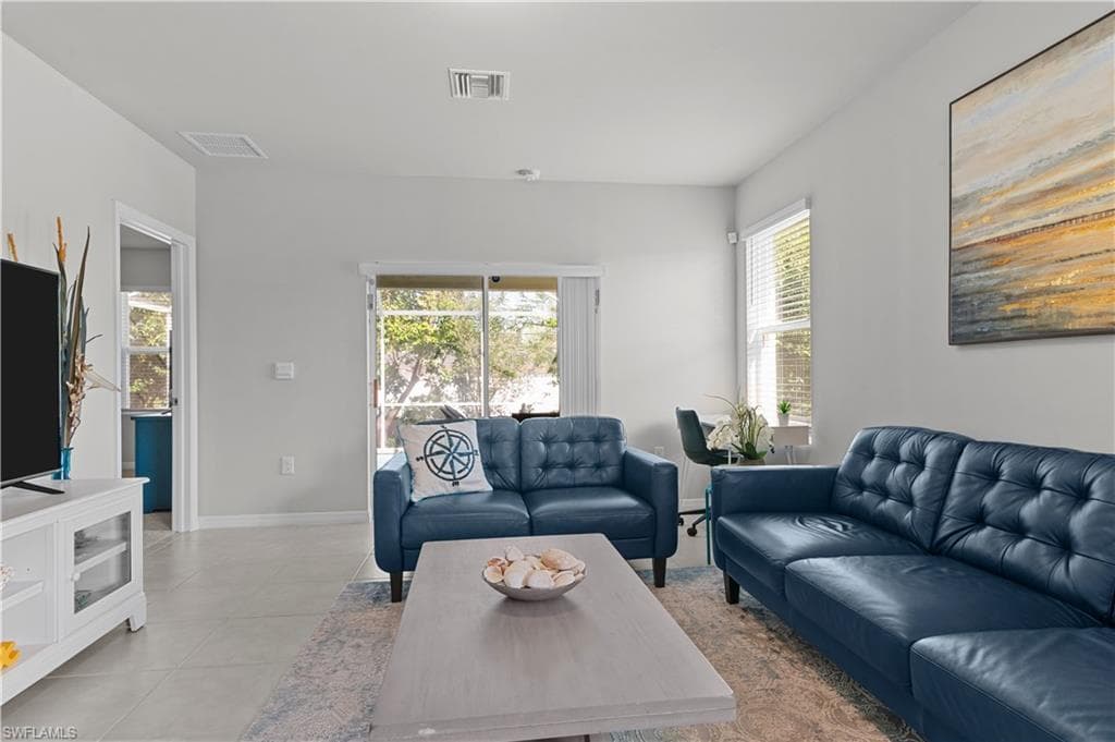 Living room with light tile patterned flooring and baseboards