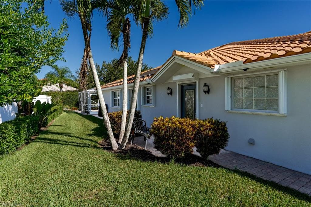 View of side of home featuring stucco siding and a tile roof