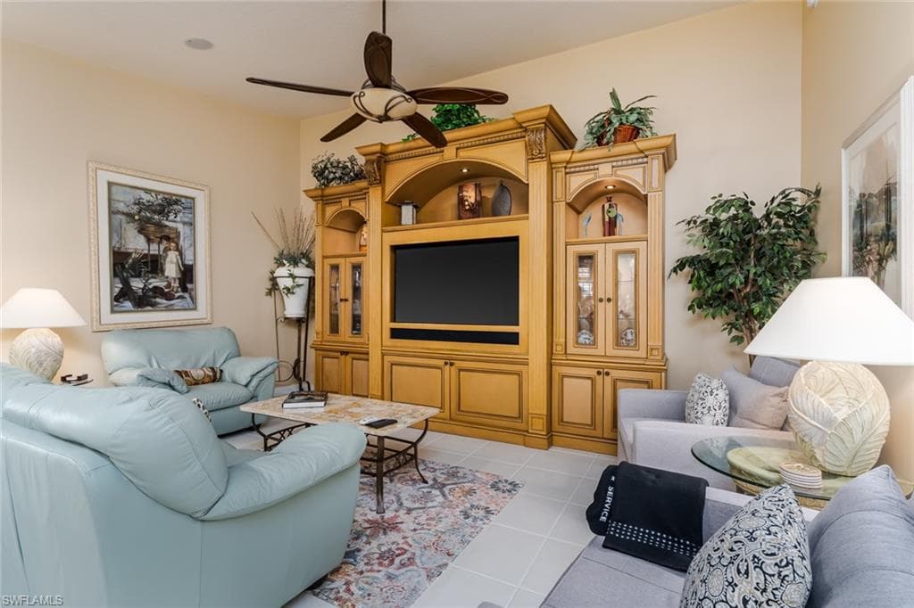 Living room featuring light tile patterned flooring and a ceiling fan