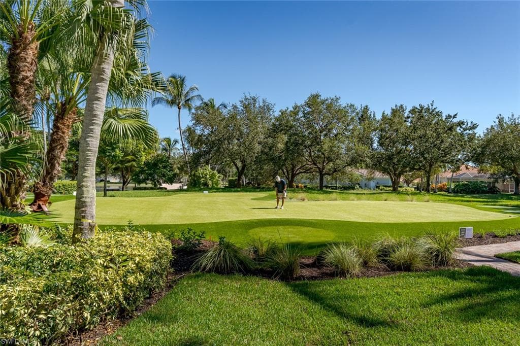 Surrounding community with a yard and golf course view