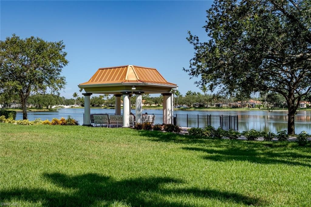 Dock featuring a lawn and a water view