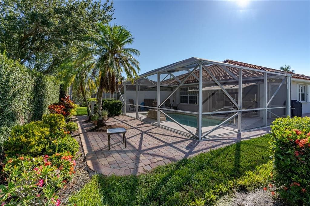 Outdoor pool featuring a sunroom, a patio area, and a lanai