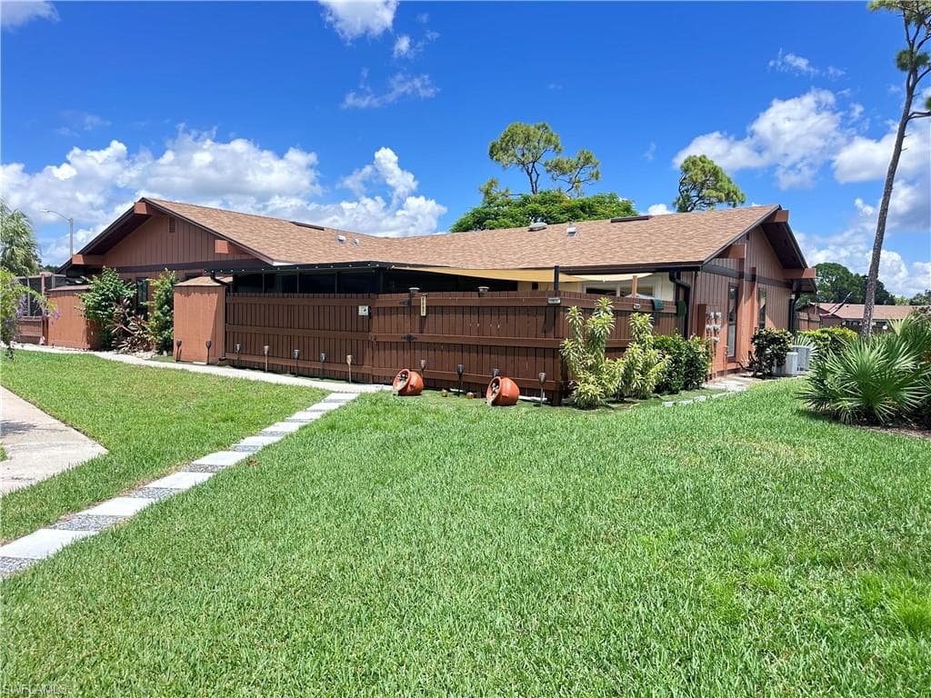 Rear view of property with roof with shingles