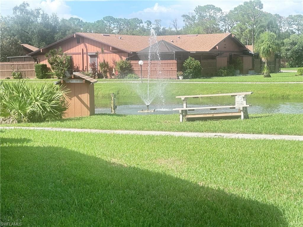 View of home's community with a water view and a yard
