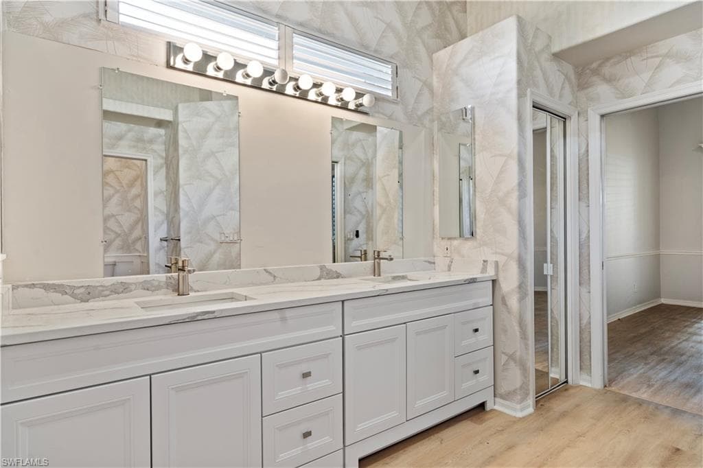 Bathroom featuring double vanity and light wood-type flooring