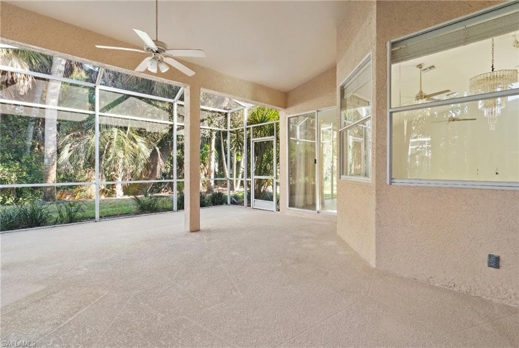 Unfurnished sunroom with a patio area and a ceiling fan
