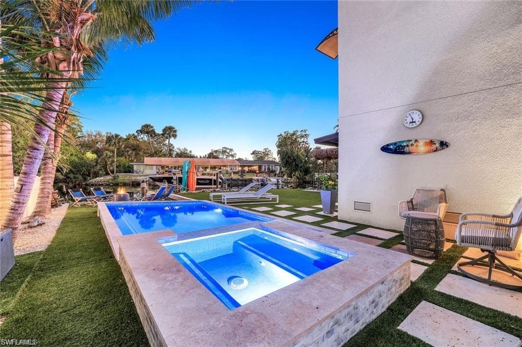 View of pool featuring a patio area, a yard, and a pool with connected hot tub