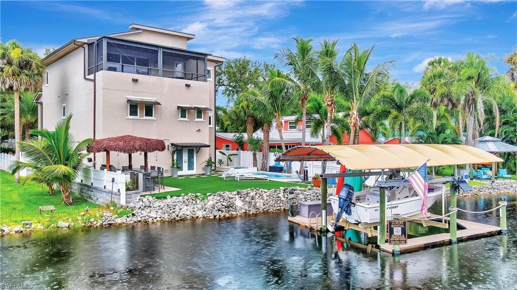 Backyard view showcasing tiki bar and covered boat lift (up to 7,000 lbs)