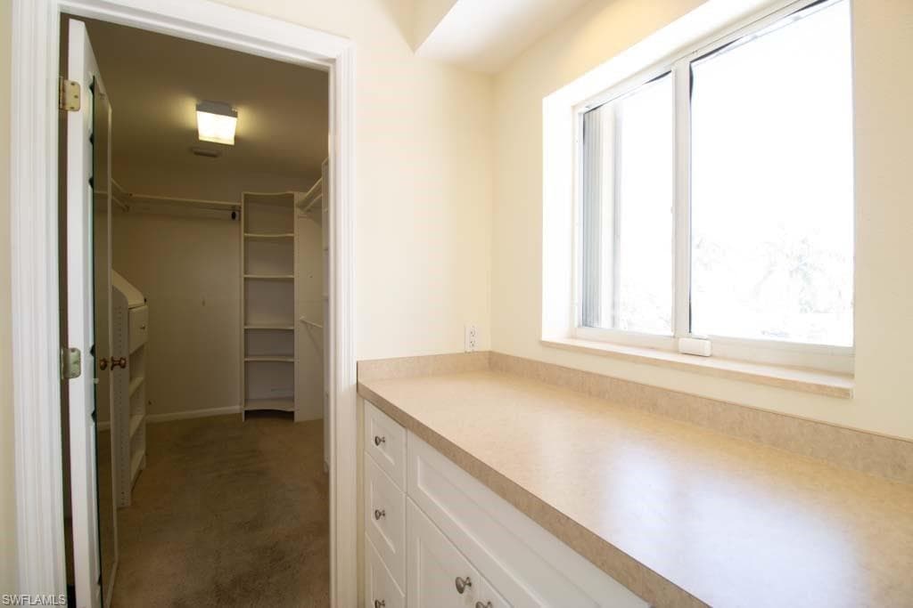 Walk in closet featuring dark carpet