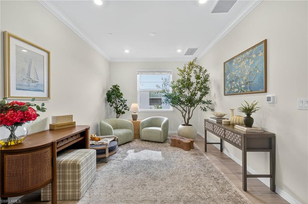 Living area featuring light wood-type flooring, crown molding, and recessed lighting