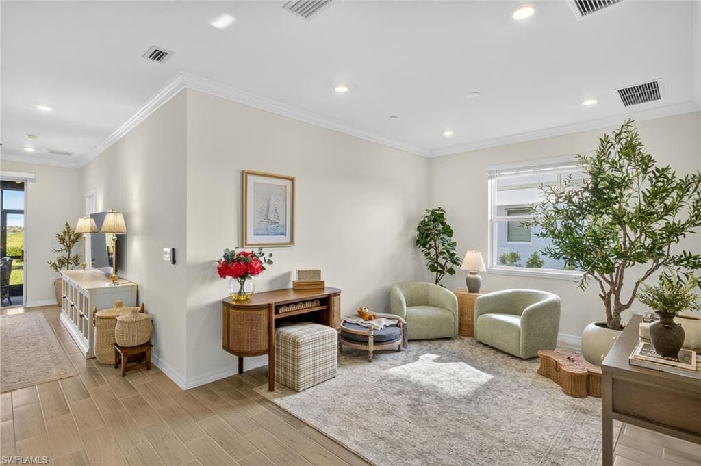 Living area featuring ornamental molding, wood tiled floors, and recessed lighting