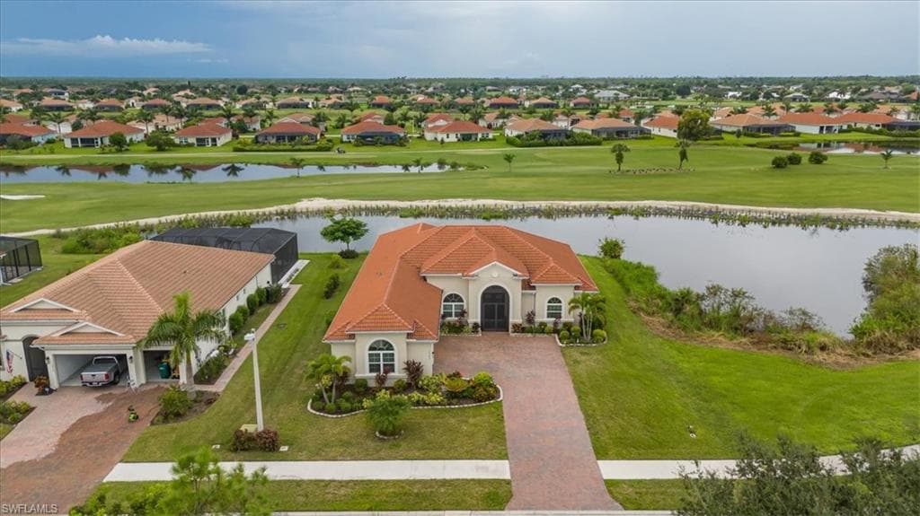Aerial perspective of suburban area featuring a large body of water and a golf course