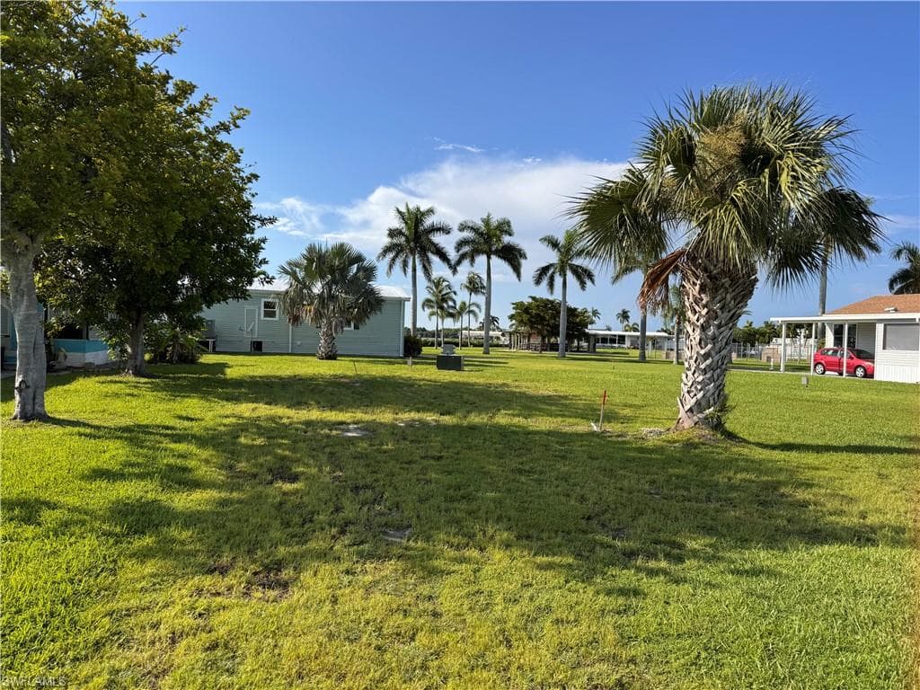 Street view of property, palm tree on property, grass
