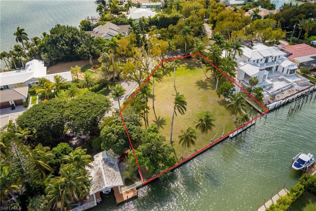 Aerial view of property and surrounding area featuring a large body of water and property parcel outlined