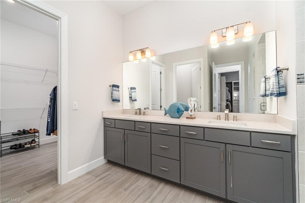 Double bowl vanity with access to secondary walk-in closet.