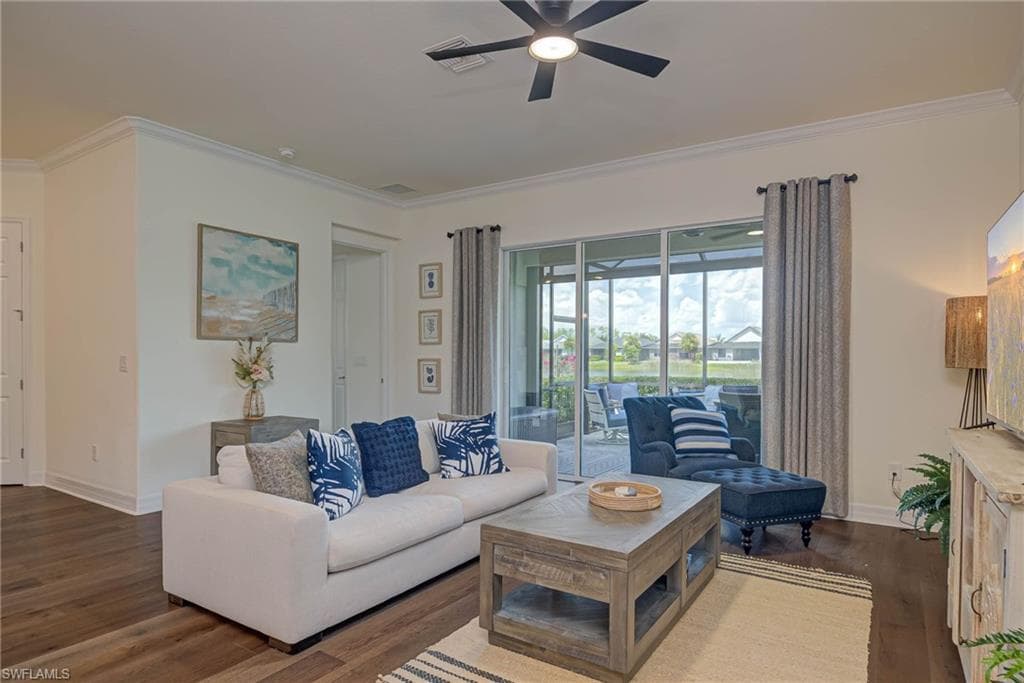 Living room featuring crown molding, dark wood-style flooring, and a ceiling fan