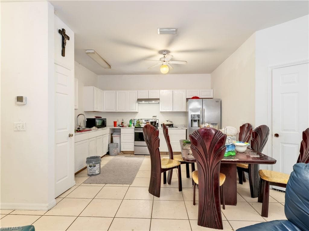 Kitchen with white cabinetry, light countertops, stainless steel appliances, a ceiling fan, and light tile patterned floors