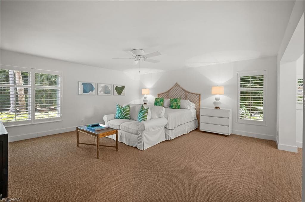 The spacious primary bedroom is light and airy surrounded by windows on three sides.