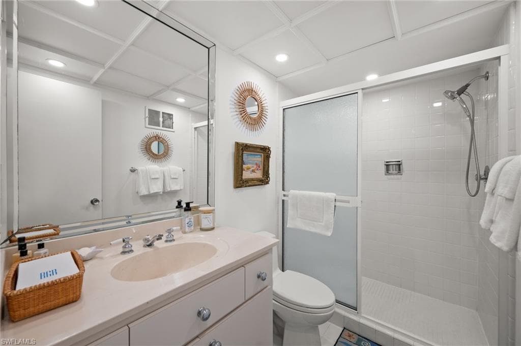 Guest bedroom 1's en-suite bathroom has an oversized shower, single vanity, oversized mirror, toilet and custom lighting!