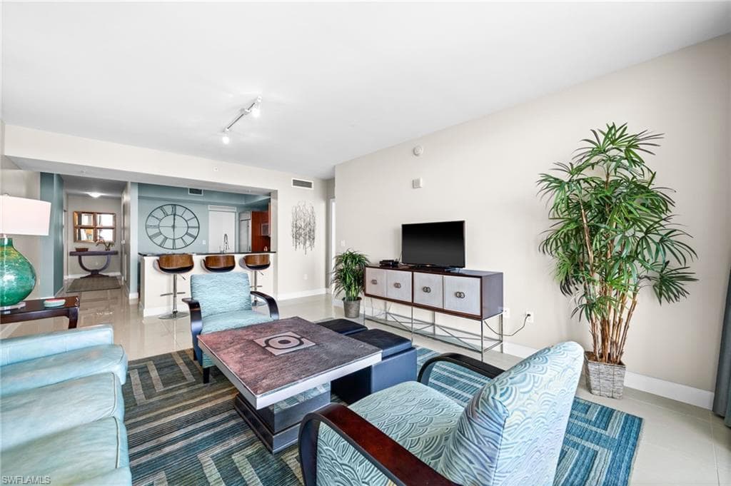 Living area featuring tile patterned floors and rail lighting