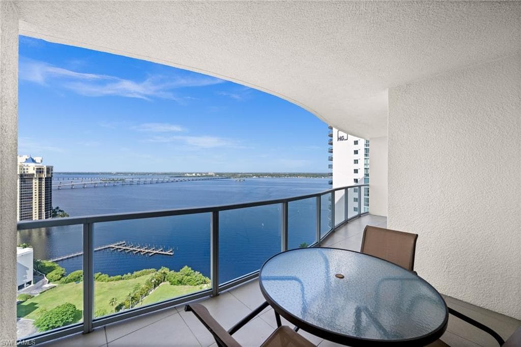 Balcony with a water view and outdoor dining space