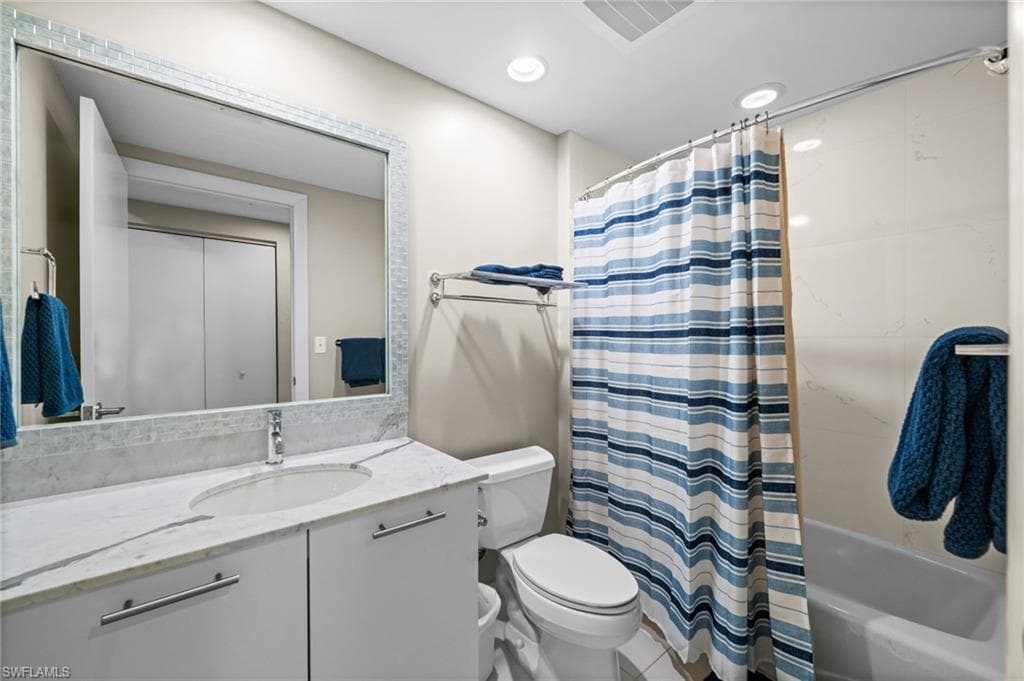 Bathroom with vanity, shower / bath combination with curtain, recessed lighting, and light tile patterned floors