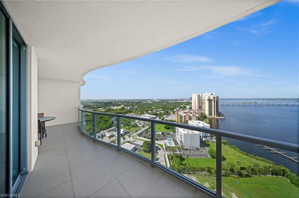 Balcony with a water view and a view of city