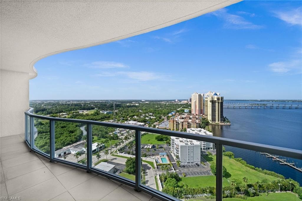 Balcony featuring a water view and a view of city