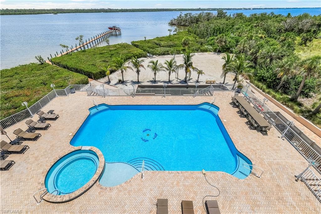 View of swimming pool, hot tub with a patio area, bocce & Volleyball courts, and a view of Lemon Bay