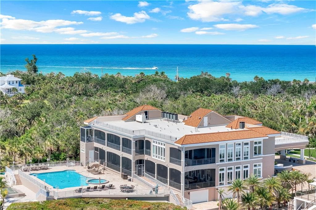 Bird's eye view of a pool area and a nearby body of water